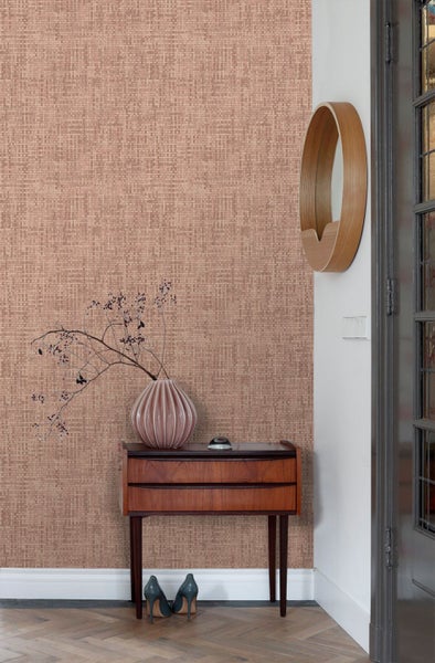 Tapete mit gewebter Textur in einem Raum mit Holztisch, Vase mit Zweigen, rundem Holzspiegel und Fischgrätparkett.