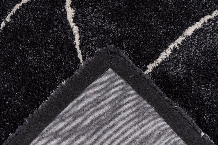 Nahaufnahme eines Hochflor-Teppichs mit Muster, zeigt den Flor und die strukturierte Rückseite.