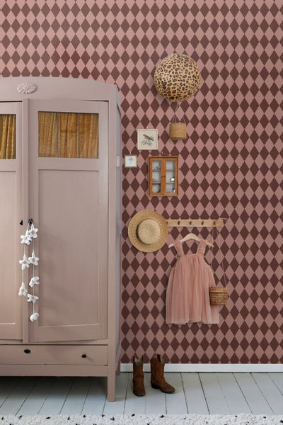 Dekoratives Kinderzimmer mit Tapete im Rautenmuster, Kleiderschrank und Accessoires.
