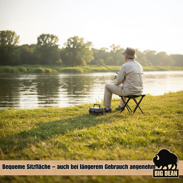 Ein Mann sitzt auf einem Klapphocker beim Angeln am Flussufer.