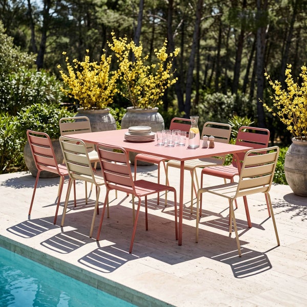 Modernes Gartenmöbel-Set mit rechteckigem Metalltisch und acht Stühlen auf einer Steinterrasse an einem Pool.