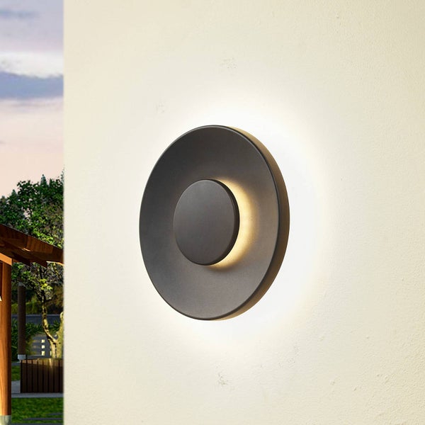 Moderne runde Außenwandleuchte mit indirekter LED-Beleuchtung an einer Wand montiert.
