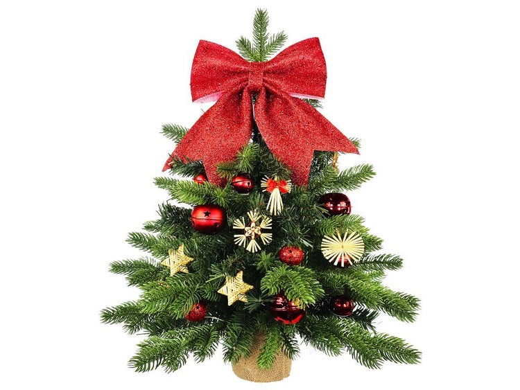 Künstlicher Weihnachtsbaum mit Schleife und Weihnachtsbaumschmuck aus Stroh und Kugeln im Jutesack.