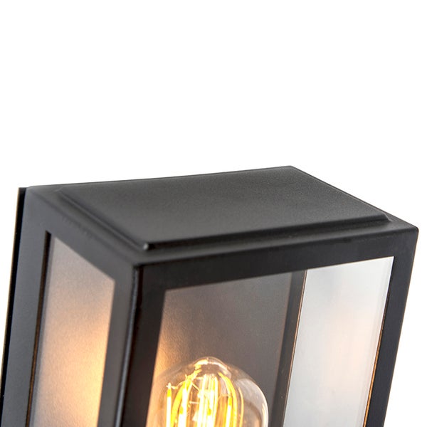 Nahaufnahme einer rechteckigen Außenwandleuchte aus schwarzem Metall und Glas mit sichtbarem Filament-Leuchtmittel.
