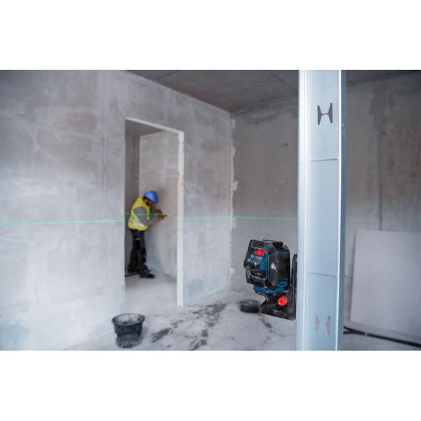 Innenraumszene mit einem Arbeiter, der mit einem Linienlaser Nivellierarbeiten durchführt