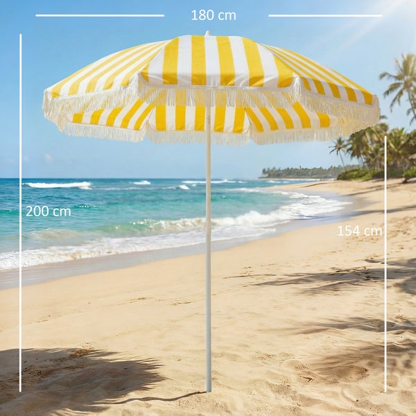 Gelb-weiß gestreifter Sonnenschirm mit Quasten im Bohème-Stil über zwei Personen in Holzliegestühlen an einem sonnigen Sandstrand am Meer.