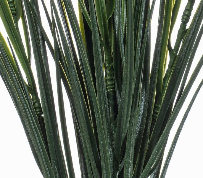 Detailaufnahme einer grünen Kunstpflanze aus Kunststoff in Form von Gras.