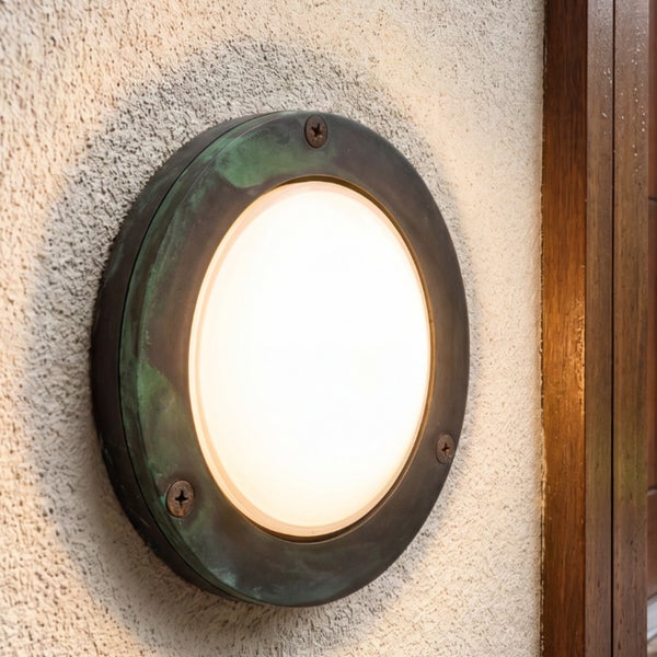 Runde Außenwandleuchte aus Metall mit Patina-Effekt und weißem Diffusor.