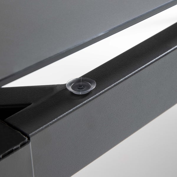 Detailaufnahme eines transparenten Saugnapfes auf einem schwarzen Metallrahmen zur Auflage einer Tischplatte.