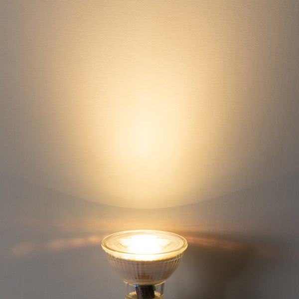 LED-Reflektorlampe mit warmweißem Lichtkegel an einer Wand.