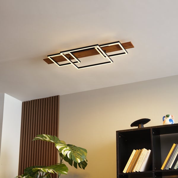 Moderne LED Deckenleuchte mit eckigen Metallrahmen und Holzelement an der Zimmerdecke in einem stilvoll eingerichteten Wohnraum