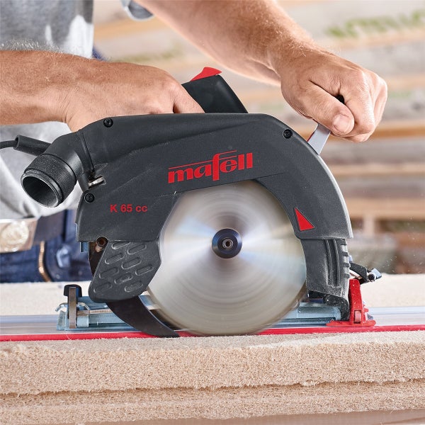 Handwerker verwendet Mafell Handkreissäge K 65 cc zum Sägen einer Holzplatte auf einer Führungsschiene.