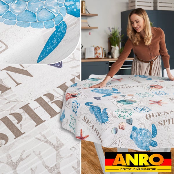 Eine Frau legt eine runde maritime Wachstuchtischdecke mit Schildkrötenmotiven in einer hellen Küche auf einen Tisch. Detailansichten. ANRO Logo.