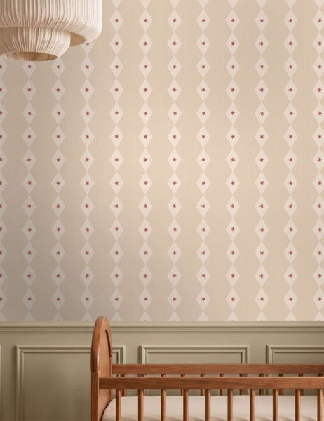 Tapete mit Rautenmuster und kleinen Sternsymbolen im Kinderzimmer, tapezierte Wand mit Holzbett im Vordergrund.