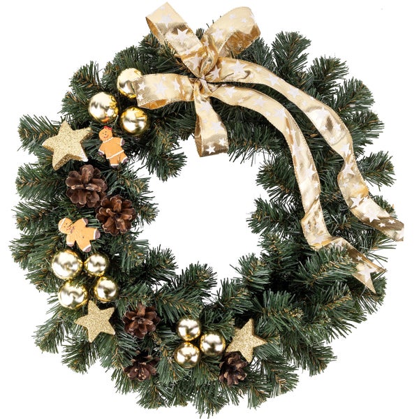 Kleiner geschmückter Weihnachtsbaum, Weihnachtskranz und Geschenkpäckchen neben einem Kamin.