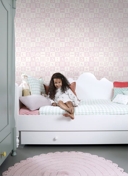 Kinderzimmer mit weißem Bett, verspielter Tapete und jungem Mädchen