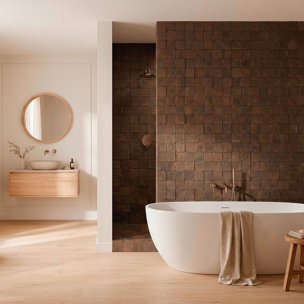 Modernes Badezimmer mit freistehender Badewanne, begehbarer Dusche mit dunkelbraunen Wandfliesen und hängendem Waschbecken mit Holzunterschrank.