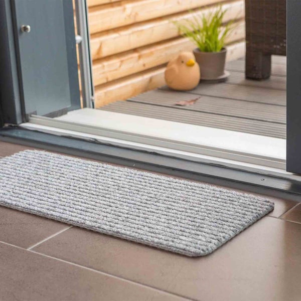 Fußmatte vor einer Terrassentür auf Fliesenboden