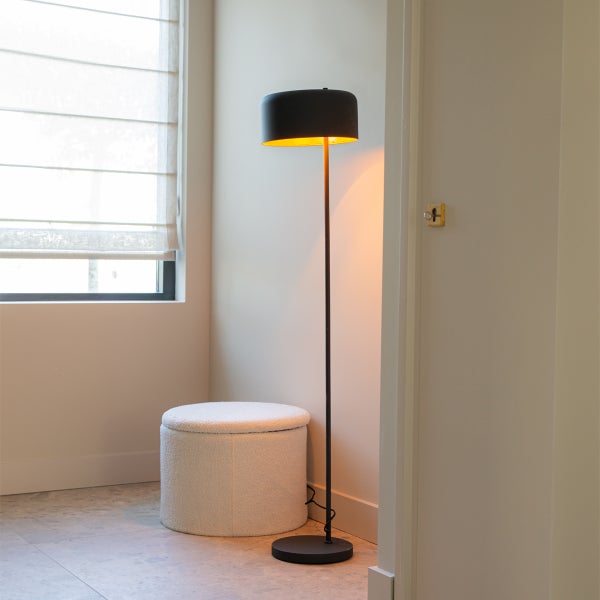 Stehlampe neben Fenster und Hocker