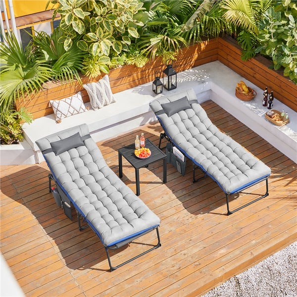 Zwei graue Sonnenliegen mit Beistelltisch auf einer Holzterrasse in einem Garten.