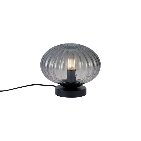 Tischleuchte mit ovalem Schirm aus geripptem Rauchglas und schwarzem Metallfuß.
