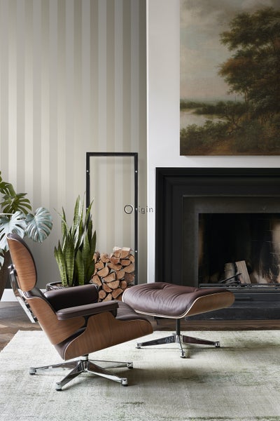 Wohnzimmer mit Sessel, Fußhocker, Kamin und Dekorationen für ein gemütliches Ambiente