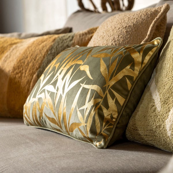 Dekorative Kissen mit Blattmuster auf einem Sofa.