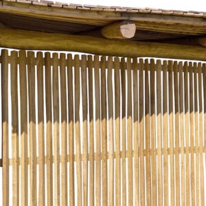 Holzsichtschutz aus vertikalen Holzlatten unter einem Holzdach.