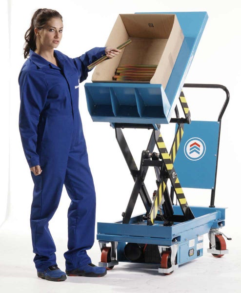 Eine Frau bedient einen blauen Scherenhubwagen mit Neigefunktion, auf dem ein Karton mit Metallteilen liegt.