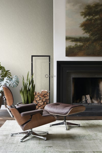 Wohnzimmer mit Sessel, Hocker, Kamin und Dekoration für eine gemütliche Atmosphäre