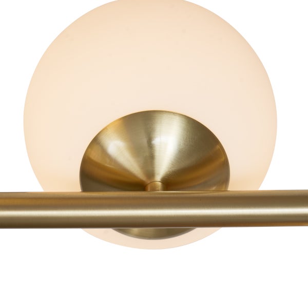 Nahaufnahme einer Lampe mit einem kugelförmigen Lampenschirm aus Glas und einer goldenen Halterung.