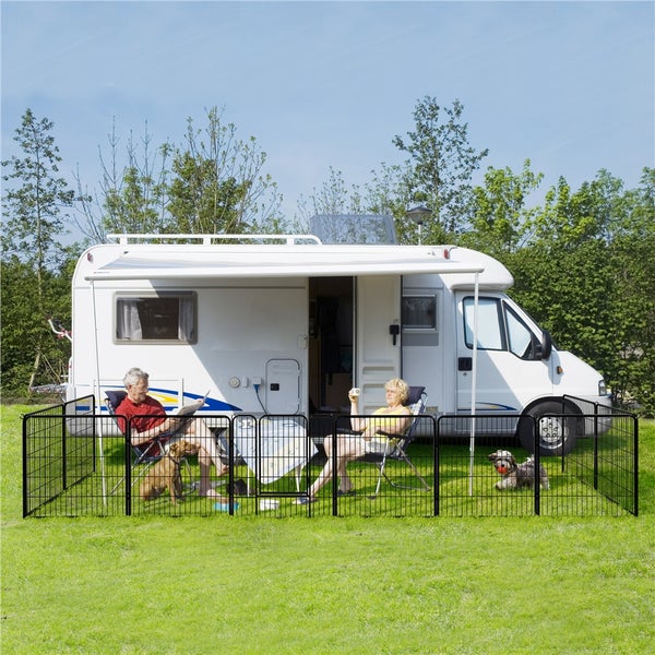 Szene mit Wohnmobil, Paar in Stühlen und einem schwarzen Hundezaun, der einen Bereich für Hunde abgrenzt