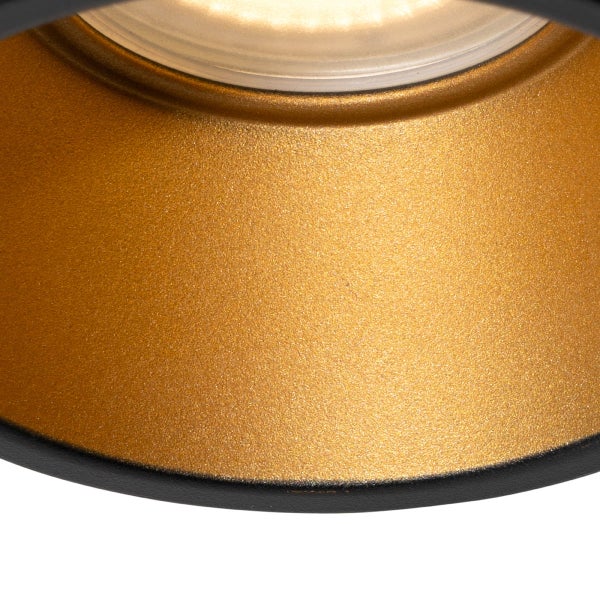 Nahaufnahme der Innenseite einer Leuchte mit goldfarbener, strukturierter Metalloberfläche und schwarzem Außenrand.