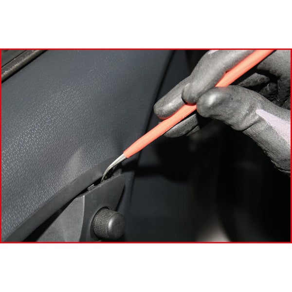 Ein Handwerker mit Handschuhen verwendet einen Hebelheber an einer Fahrzeugtürverkleidung.