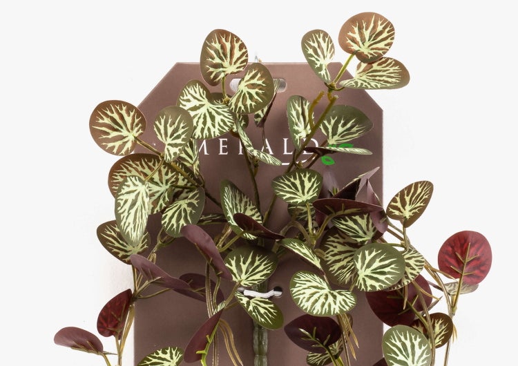 Künstliche Hängepflanze mit runden, gemusterten Blättern und Emerald Logo.