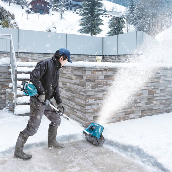 Eine Person benutzt eine Makita Schneefräse im Wintergarten