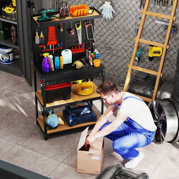 Ein Mann in blauem Blaumann kniet in einer organisierten Garage neben einer schwarzen Werkbank mit Lochwand und verschiedenen Werkzeugen.