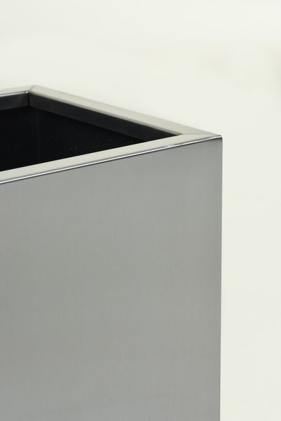 Detailansicht der Ecke eines rechteckigen Pflanzgefäßes aus gebürstetem Metall.