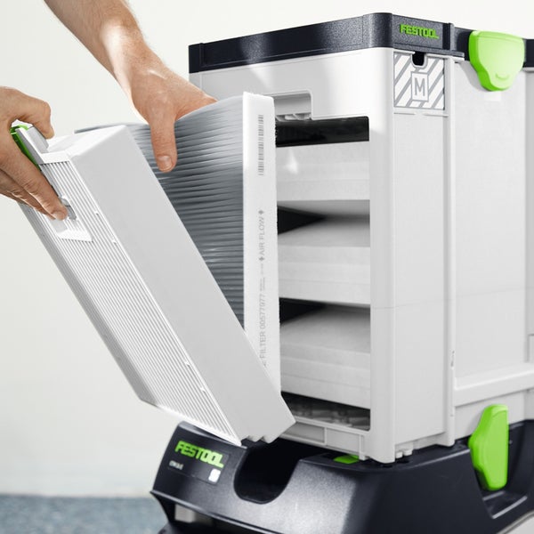 Hände setzen einen Hauptfilter in ein Festool Absaugmobil ein.