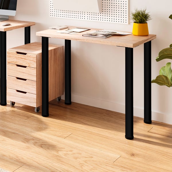 Schreibtisch mit Holzoptik Tischplatte und vier runden schwarzen Metallbeinen in einem modernen Arbeitszimmer mit Rollcontainer.