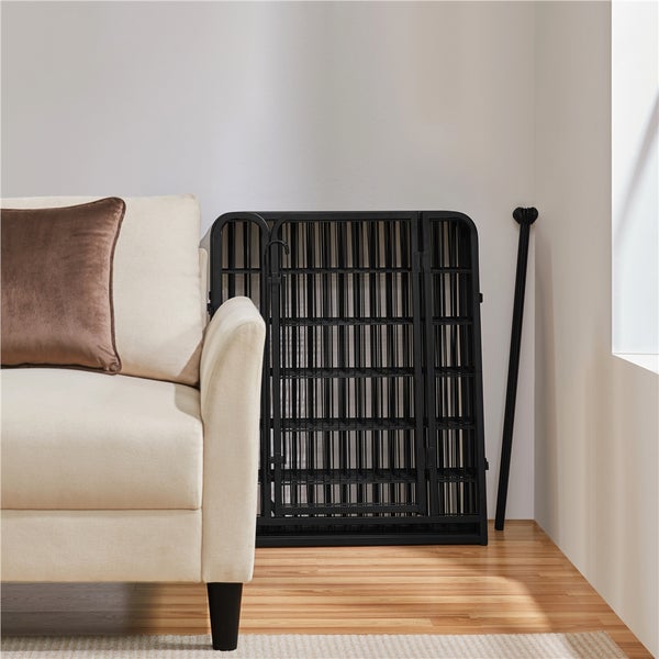 Zusammengeklappbares, schwarzes Schutzgitter neben einem Sofa