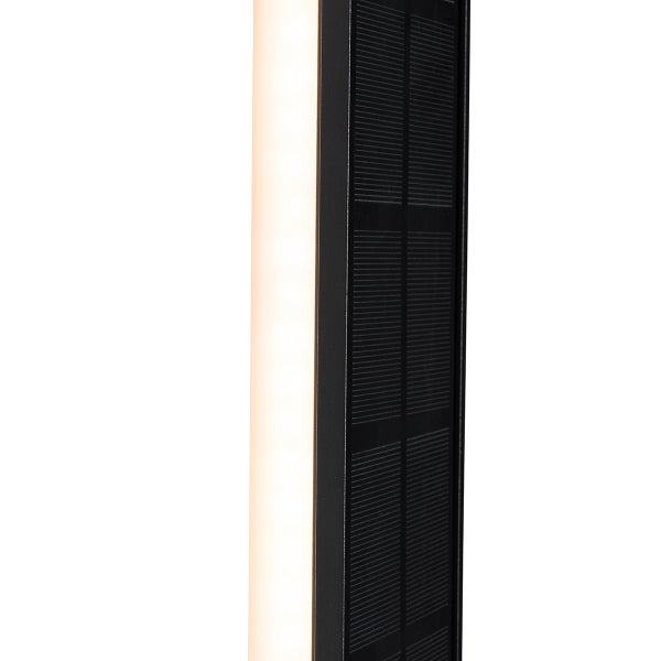 Nahaufnahme einer Solarleuchte mit leuchtendem LED-Panel und Solarzellen.