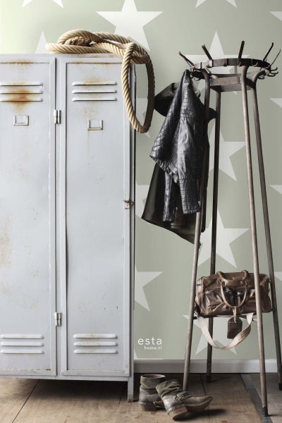 Dekoratives Interieur mit Metallschrank, Kleiderständer, Seil und Accessoires vor einer Wand mit Sternmuster