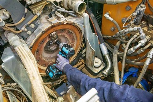 Mechaniker benutzt einen Akku-Schlagschrauber an einer Maschinenreparatur.