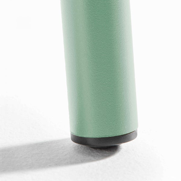 Nahaufnahme eines grünen Möbelfußes aus Metall mit einem schwarzen Kunststoffgleiter.