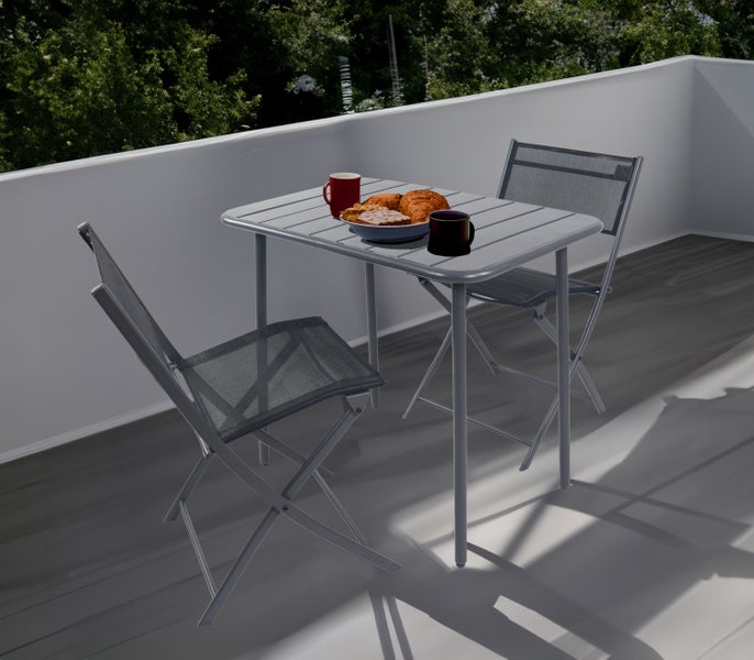 Balkonszene mit Tisch und zwei Klappstühlen mit Frühstück