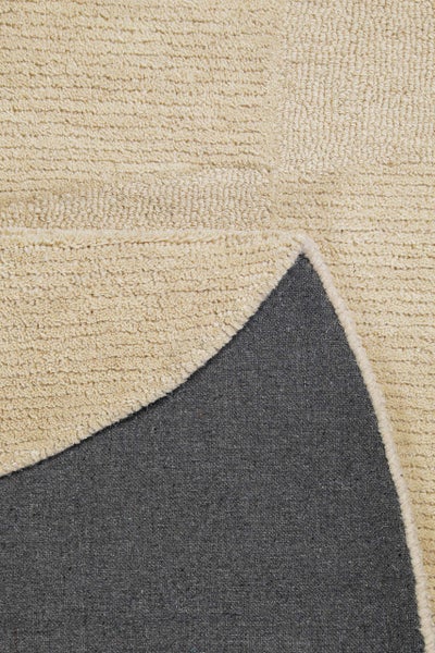 Detailaufnahme eines Teppichs mit strukturierter Oberfläche und dunkler Rückseite.
