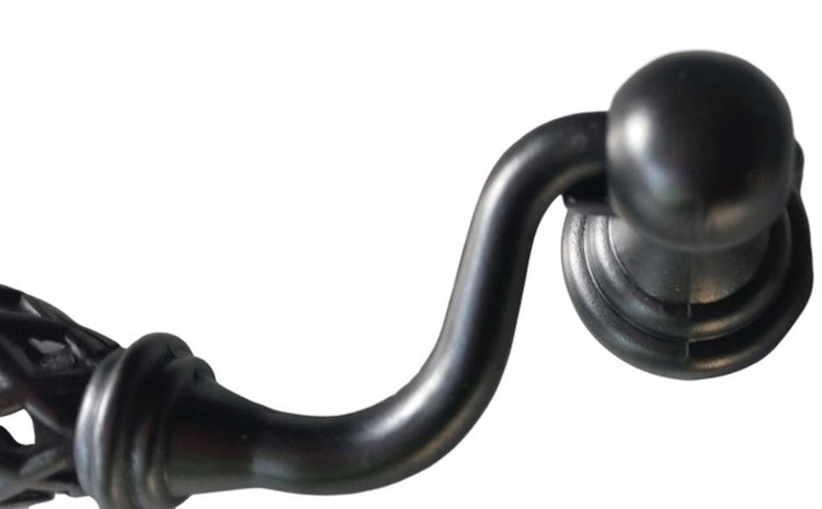 Ein einzelner geschwungener Möbelgriff aus Metall in nostalgischem Design zur Befestigung an Schränken oder Schubladen.