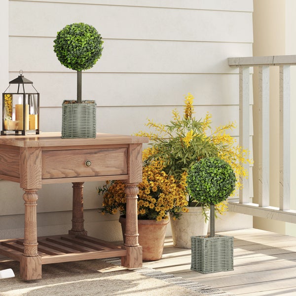 Szene mit künstlichen Buchsbäumen im Topf auf einer Holzterrasse