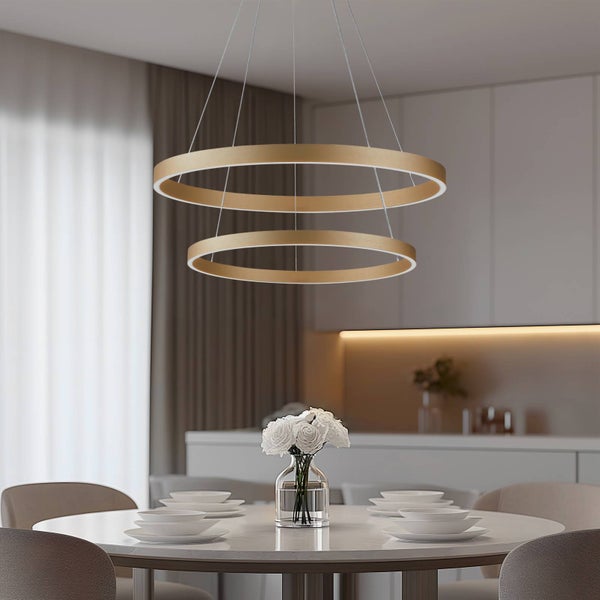 Moderne goldfarbene LED-Pendelleuchte mit zwei Ringen über einem gedeckten Esstisch in einem hellen, zeitgemäßen Esszimmer.